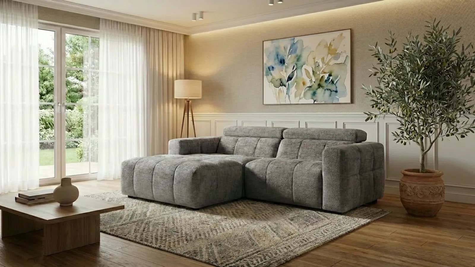 The same grey sectional sofa staged in a warm, sunlit living room with a rug, artwork and an olive tree
